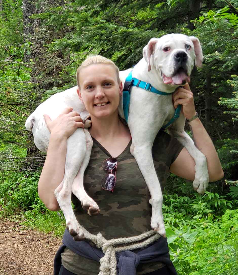 Stephanie Carrying Dog on a Hike